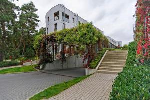 a building with stairs and flowers in front of it at Nadmorski Dwór by Grand Apartments in Gdańsk