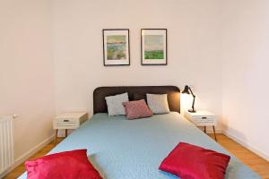 a bedroom with a large bed with red pillows at Nadmorski Dwór by Grand Apartments in Gdańsk