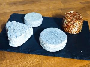 Drei Käsesorten und ein Hamburger auf einem Schneidebrett in der Unterkunft Par les Prés et les Bois de Sologne in Bauzy