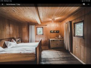 - une chambre avec un lit et un mur en bois dans l'établissement Knottn Hüttl, St. Pankraz/Ulten, Nähe Meran, à San Pancrazio