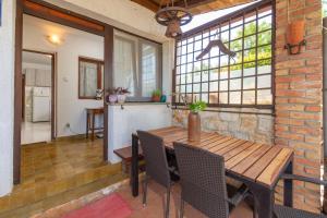 een eetkamer met een houten tafel en een aantal ramen bij Apartment Adriana on peaceful location with pool in Pula