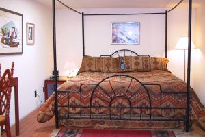 - une chambre avec un lit avec un cadre métallique dans l'établissement Casas de Suenos Old Town Historic Inn, Ascend Hotel Collection, à Albuquerque