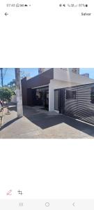 un bâtiment avec une porte de garage noire dans une rue dans l'établissement Araras Apart Service Caldas Novas, à Caldas Novas