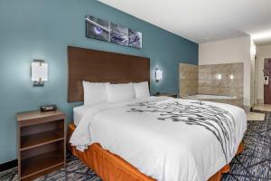 a hotel room with a large bed and blue walls at Sleep Inn & Suites Augusta West Near Fort Eisenhower in Grovetown