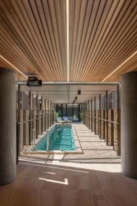 a swimming pool in a building with a wooden ceiling at Vibe Hotel Adelaide in Adelaide