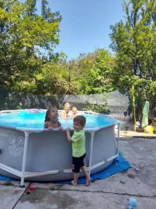 dos niños parados frente a una piscina en Apartman Mata, en Soko Banja
