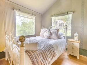 a bedroom with a white bed and a window at Foxglove - Uk43604 in Llangyniew