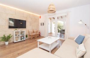 a living room with a white couch and a table at Villa Ohana by Sonne Villas in Cala Galdana