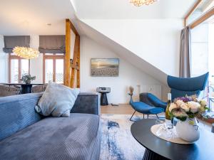een woonkamer met een blauwe bank en een tafel bij Villa Linquenda App 6 in Ahlbeck