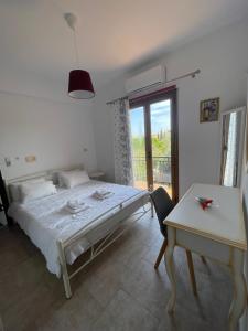 een slaapkamer met een bed, een tafel en een raam bij Kapodistriou Apartments in Aegina Town