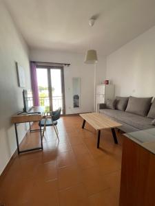 een woonkamer met een bank en een tafel bij Kapodistriou Apartments in Aegina Town