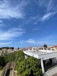 een uitzicht op een gebouw met een blauwe lucht bij Kapodistriou Apartments in Aegina Town