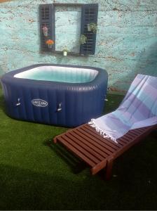 a bench and a tub in a yard with a chair at Authentic Stone House with an outdoor living room in Jezera