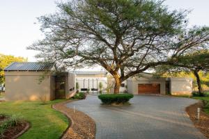 una casa con un árbol delante de una entrada en Elim Lakeside House, en Elim