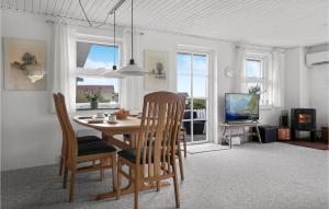 a dining room with a table and chairs and a television at 2 Bedroom Cozy Home In Lemvig in Lemvig
