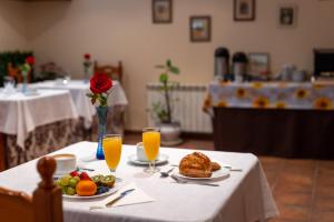 a table with a plate of food and orange juice at Posada El Trasmerano in Argoños