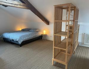 1 dormitorio con cama y estantería de madera en Les Quartiers d'Annelise, en Verdún