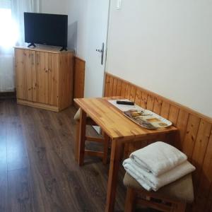 ソンバトヘイにあるKispipa Panzióのリビングルーム(木製テーブル、テレビ付)