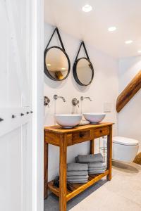 two sinks on a wooden table in a bathroom at Authentic apartment in farmhouse near Amsterdam in Ilpendam