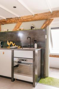 a kitchen with a stainless steel counter and a sink at Authentic apartment in farmhouse near Amsterdam in Ilpendam