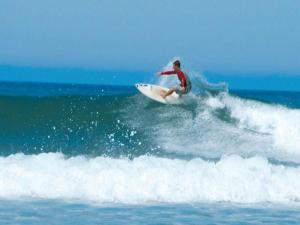 un homme faisant une vague sur une planche de surf dans l'océan dans l'établissement Appartement Capbreton, 3 pièces, 4 personnes - FR-1-239-453, à Capbreton