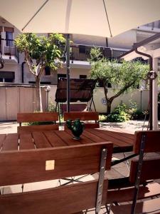 Casa ideale per la tua vacanza في بيسكارا: طاولة خشبية مع كرسيين ومظلة