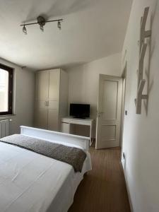 biała sypialnia z łóżkiem i telewizorem w obiekcie Casa ideale per la tua vacanza w mieście Pescara