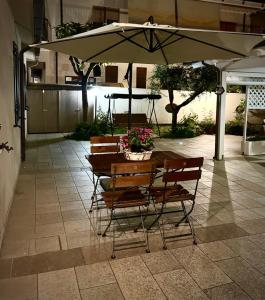 Casa ideale per la tua vacanza في بيسكارا: طاولة وكراسي تحت مظلة على الفناء