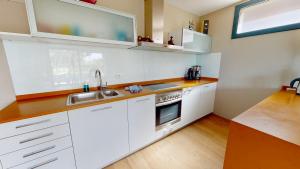 uma cozinha com armários brancos e um lavatório em Nirvana em L'Ampolla