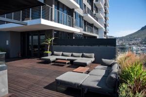 a patio with couches and tables on a building at Magnificent penthouse with breathtaking views in Cape Town