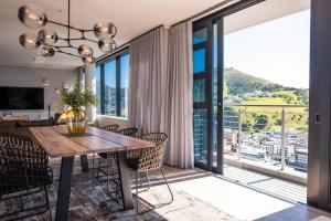 comedor con mesa y sillas y ventana grande en Magnificent penthouse with breathtaking views en Ciudad del Cabo
