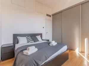 una camera da letto con un letto grande con asciugamani sopra di The Best Rent - Modern two-bedroom apartment near Navigli a Milano Altre 10 foto