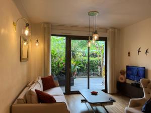 a living room with a couch and a table at Terrasse Zen - Confort Nature & Accessibilité - 4 personnes - Parking gratuit - 20 min de Paris in Asnières-sur-Seine