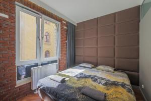 sypialnia z łóżkiem i ścianą z cegły w obiekcie ApartMate- Perfect Apartment Oldtown Gdansk w Gdańsku