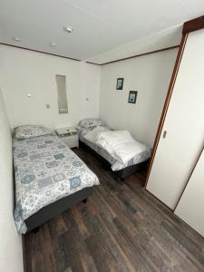 two beds in a small room with wooden floors at Chalet 58 ''Pollie'' in Hattemerbroek