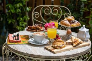 a table with a breakfast of croissants and coffee and orange juice at Secret Garden Firenze B&B in Florence