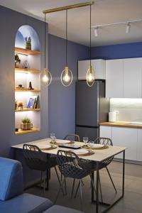 a dining room with a table and chairs and lights at Vibrant Apartment in Tirana