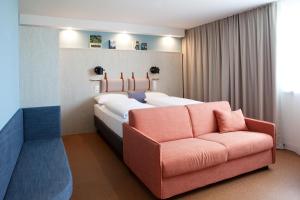 a bedroom with a large bed and a couch at greet Wien City Nord in Vienna