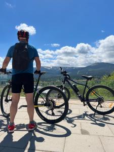 a man standing next to his bike on a hill at Dolina Wikingów-apartament Suite z tarasem w ogrodzie, miejscem w garażu i dostępem do strefy wellness in Szklarska Poręba