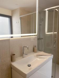 een badkamer met een wastafel en een douche bij BUNASTA Apartments in Białystok