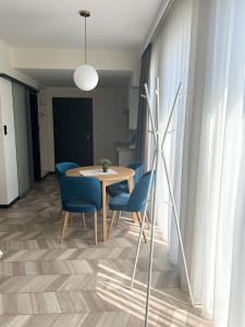 een eetkamer met een tafel en blauwe stoelen bij BUNASTA Apartments in Białystok