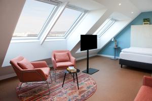 a attic living room with two chairs and a tv at greet Wien City Nord in Vienna