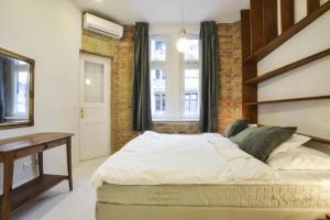 a bedroom with a large bed and a desk at Golden Leaf Apartment in Budapest