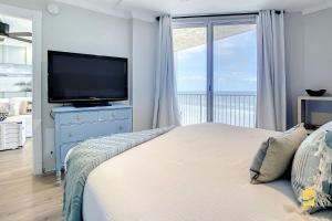 a bedroom with a flat screen tv and a bed at Oceania Beach Club Superior Beachfront Condos in New Smyrna Beach