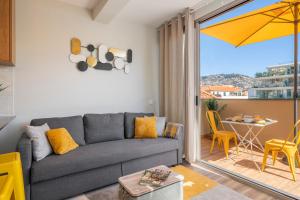 a living room with a couch and a table with a yellow umbrella at Alegria Flat by An Island Apart in Funchal