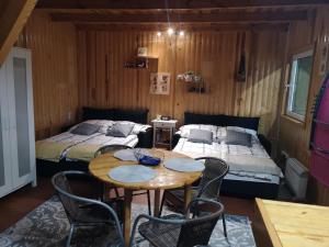 een kamer met 2 bedden en een tafel en stoelen bij domki nad jeziorem, las, do 10 osób jezioro Wilczyńskie Budzisławskie - domek letniskowy osobno ogrodzony, ogrzewany - wielkopolska, 62-550 Zygmuntowo gm Wilczyn in Zygmuntowo