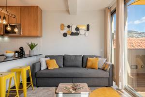 a living room with a couch and a kitchen at Alegria Flat by An Island Apart in Funchal +34 photos