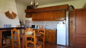 eine Küche mit einem Tisch und einem weißen Kühlschrank in der Unterkunft Quinta Da Prova in Arcos de Valdevez