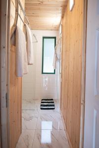 a bathroom with wood paneling and a shower with a window at Volcz Családi Birtok in Ajka