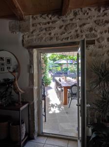 an open door to a patio with a table and chairs at mas de manon in Valréas